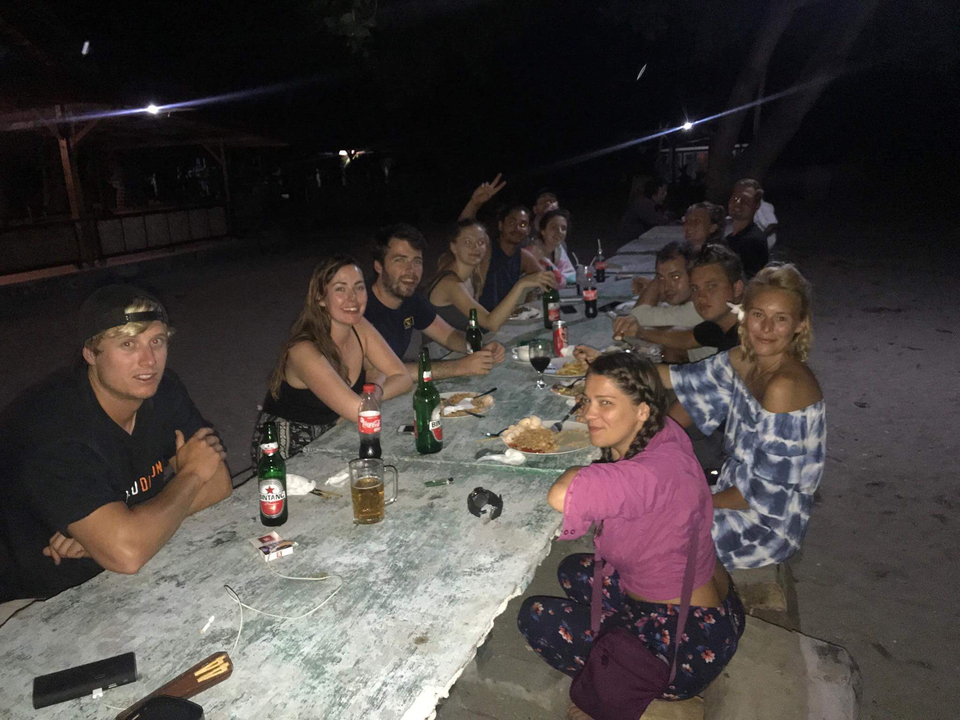 Un groupe de personnes dînant en plein air la nuit.