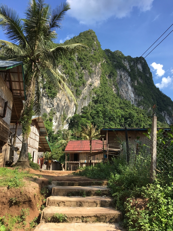 Village houses with steep mountain cliffs towering behind.