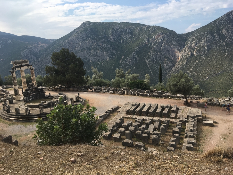 Ruines de temple sur une colline avec un arrière-plan montagneux.