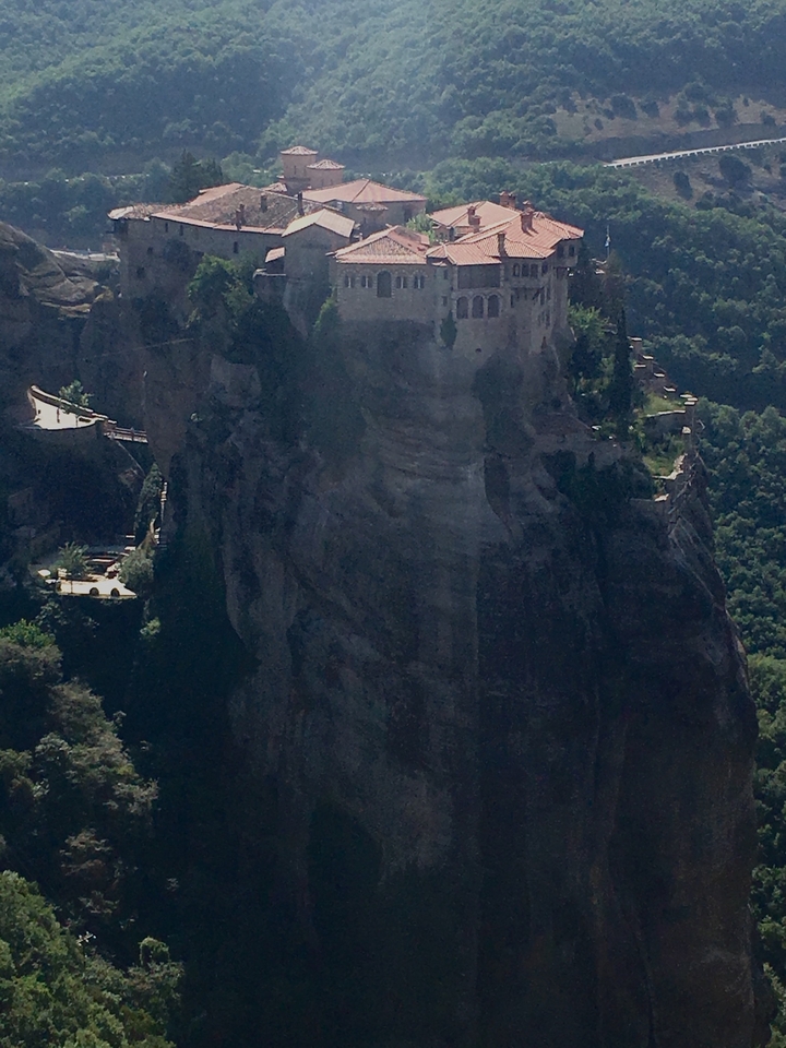 Un monastère perché au sommet d'un rocher élevé.