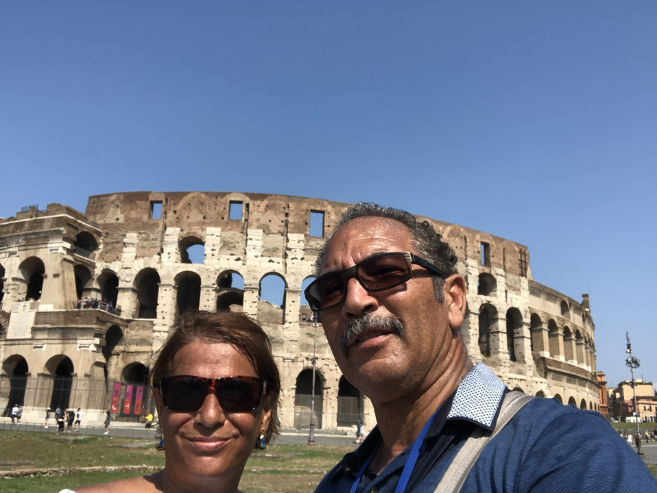 Couple posing in front of the Colosseum.