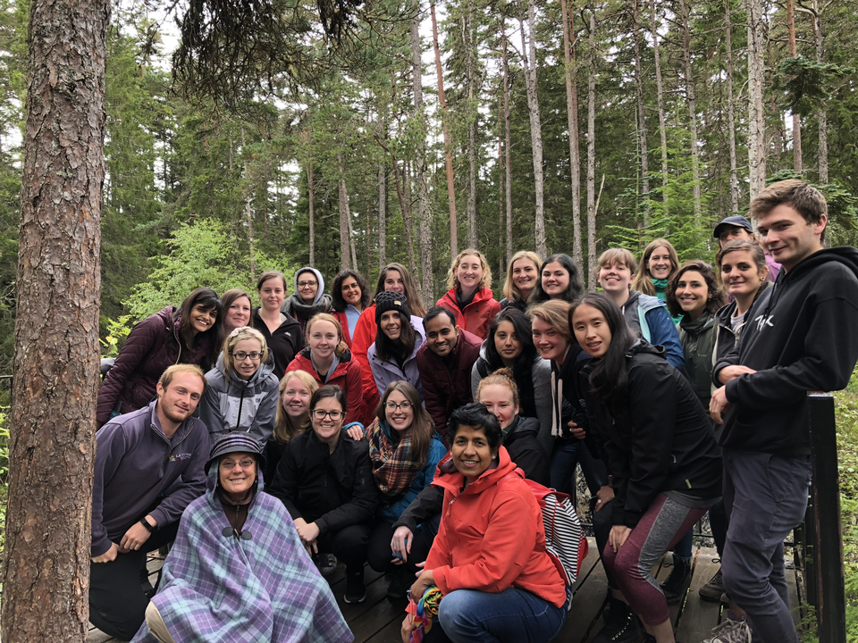 Group of people posing in a dense forest setting.