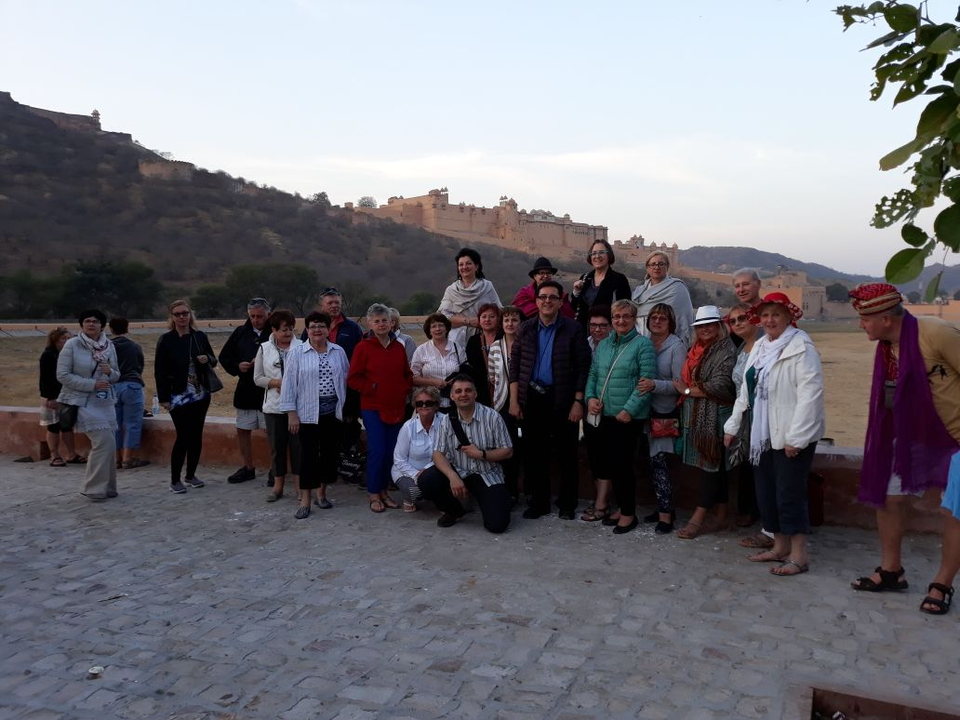 Groupe de personnes posant avec un fort en arrière-plan.