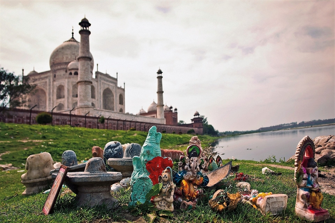 Vue du Taj Mahal avec de petites sculptures religieuses au premier plan.