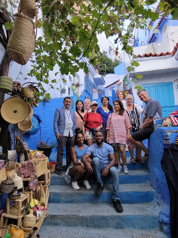 Group of people posing on blue-painted steps.