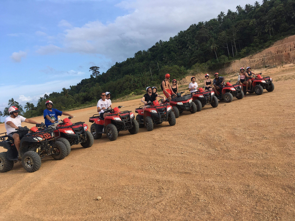 People on ATVs in a tropical setting.