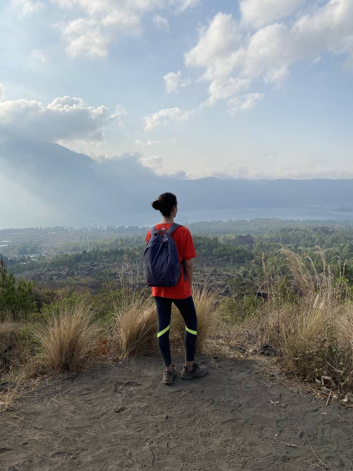 Person standing on a hillside overlooking a view