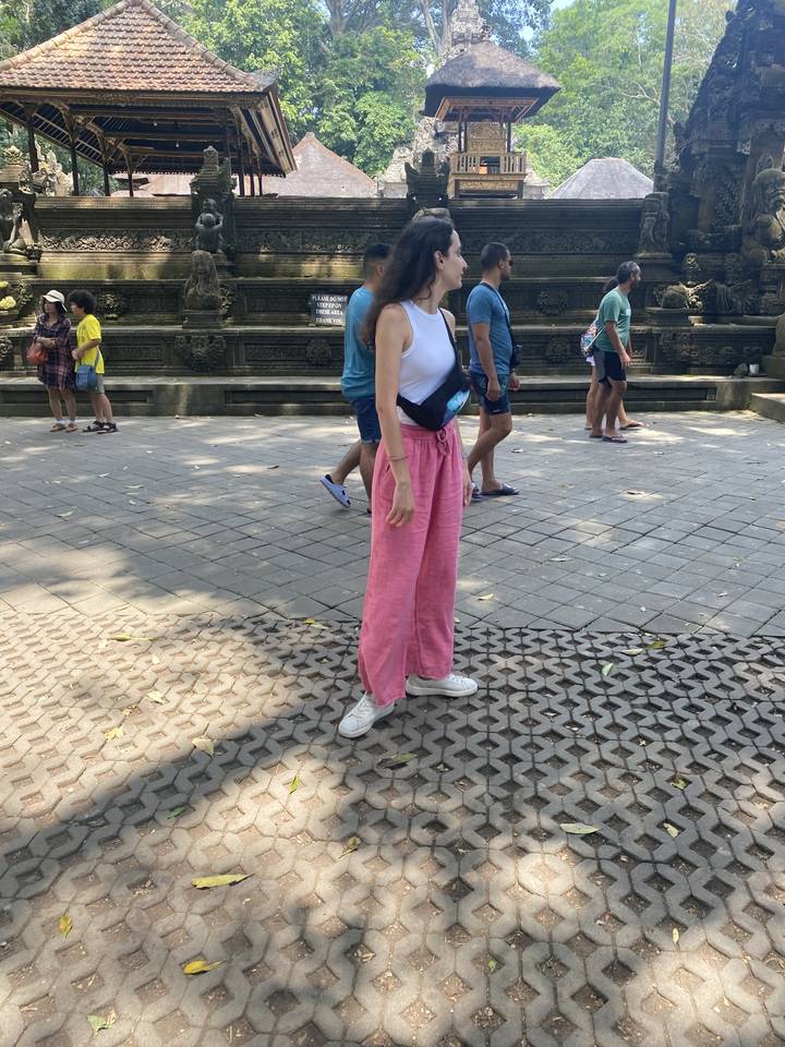 People standing in a historic outdoor location with stone architecture.