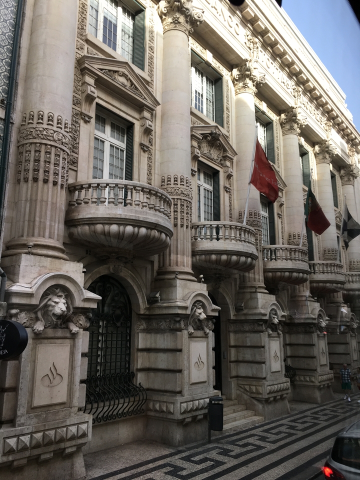 Grand building facade with flags and architectural details.