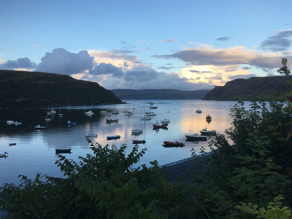 Une baie avec de nombreux bateaux à l'ancre sous un ciel nuageux dramatique.