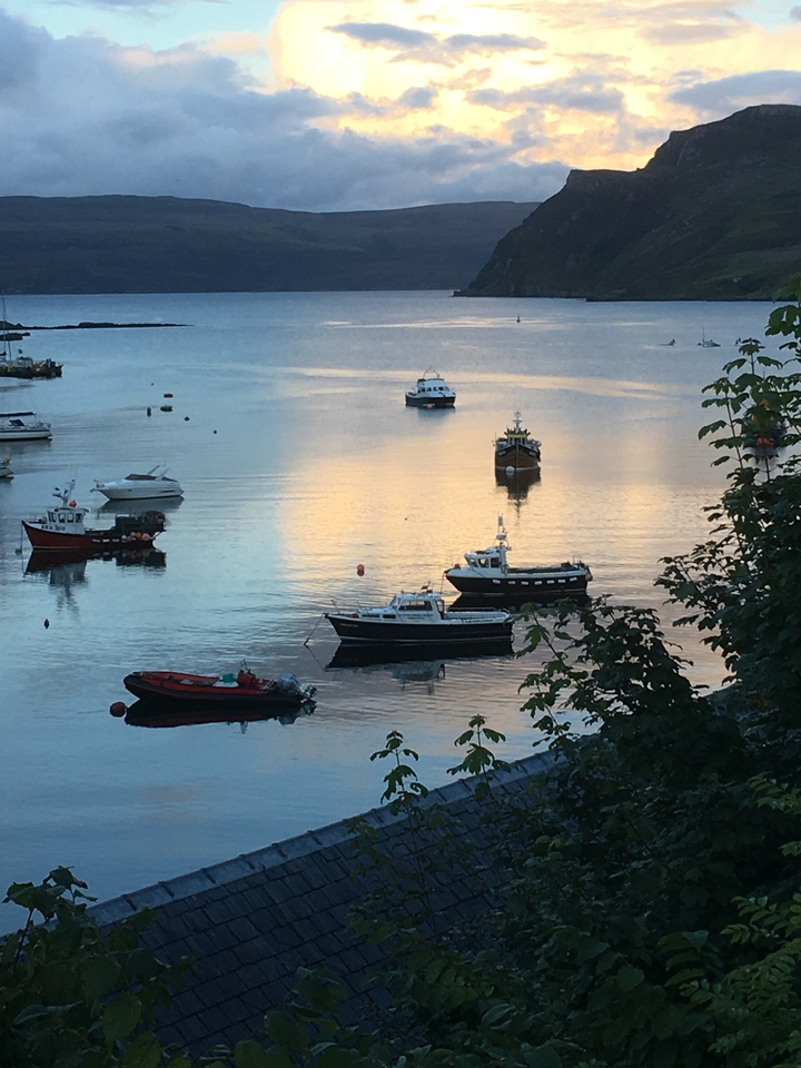 Des bateaux se reflétant sur l'eau calme pendant un coucher de soleil.