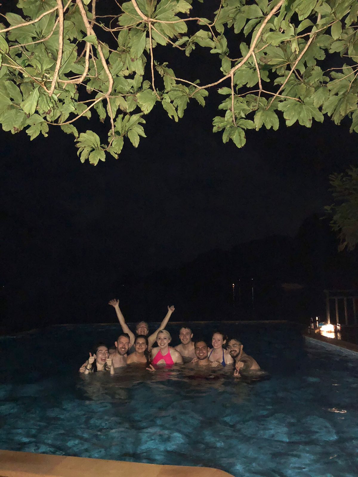 People in a dark setting with arms raised.