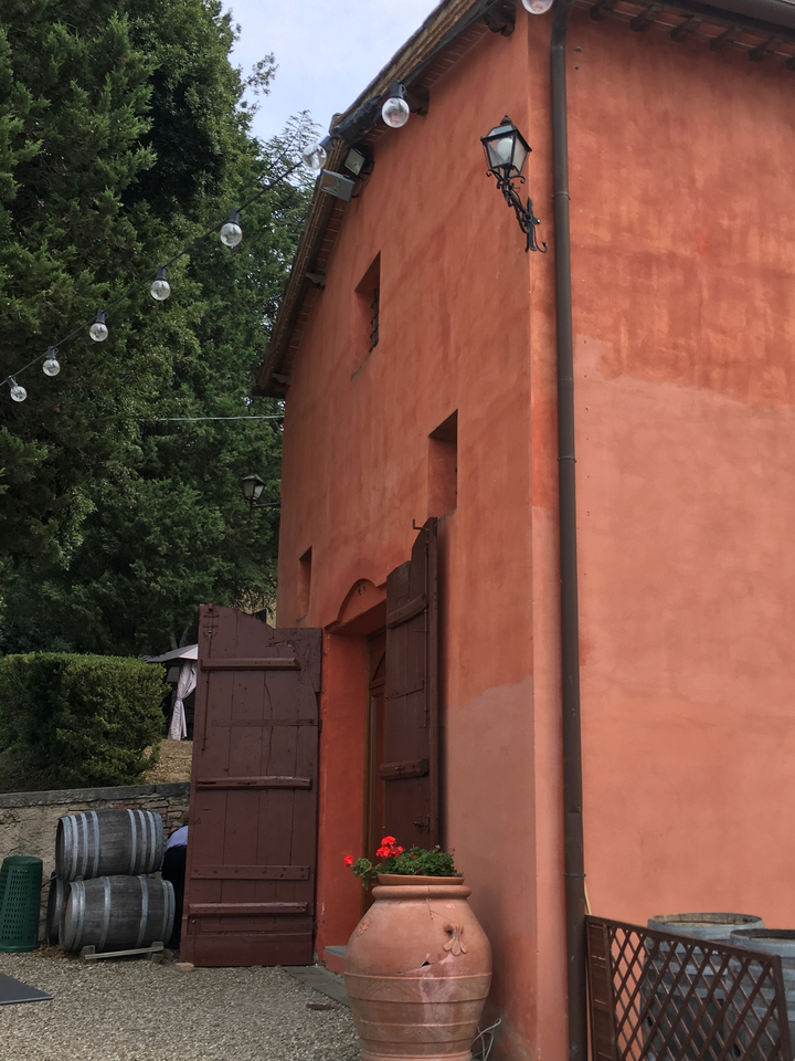 Building with terracotta walls and open door.