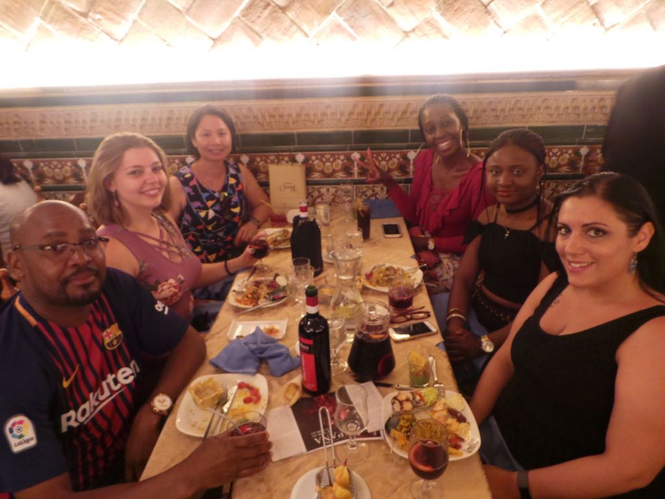 Group of people sitting at a table enjoying a meal in a restaurant.