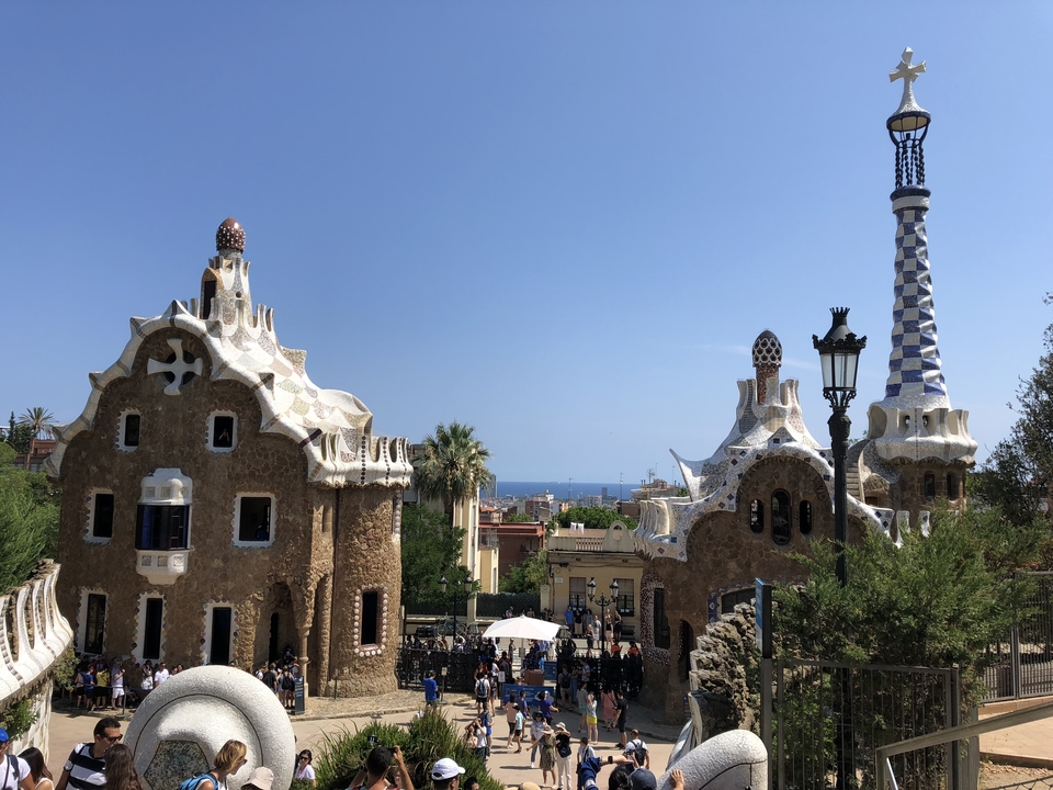 Bâtiments colorés et uniques avec des flèches, probablement dans un parc, avec des gens à proximité.
