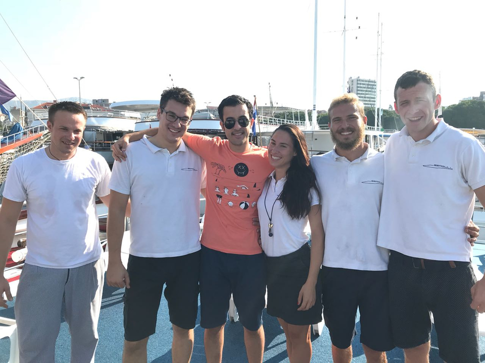 Groupe de personnes posant ensemble sur un quai devant des bateaux.