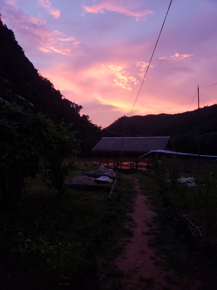 Sunset over a rural landscape with hills.