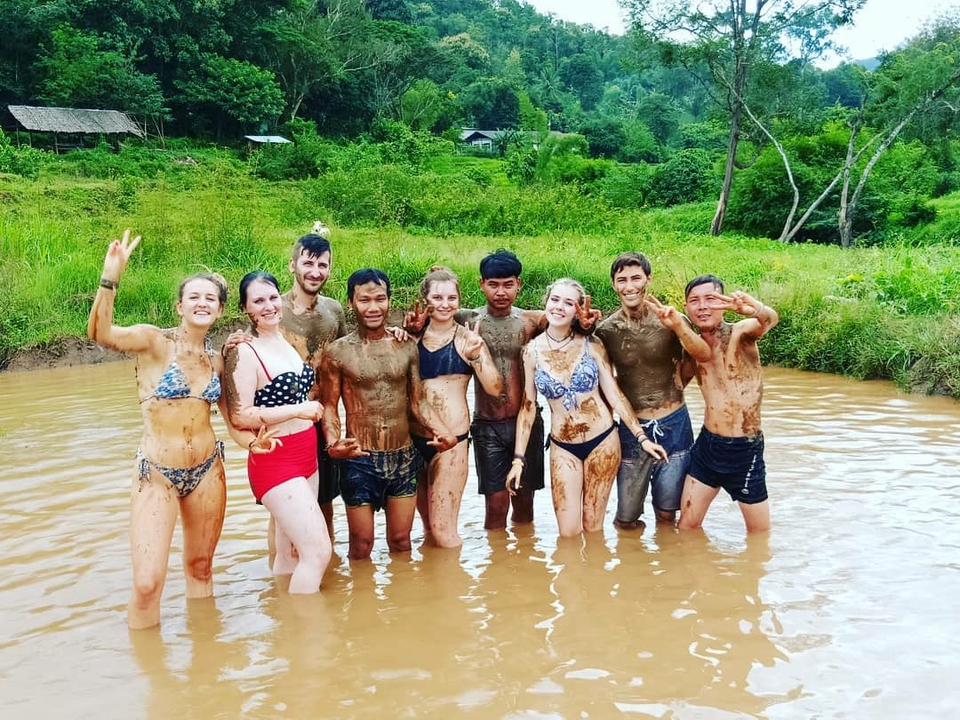 Group of people playing in muddy water.