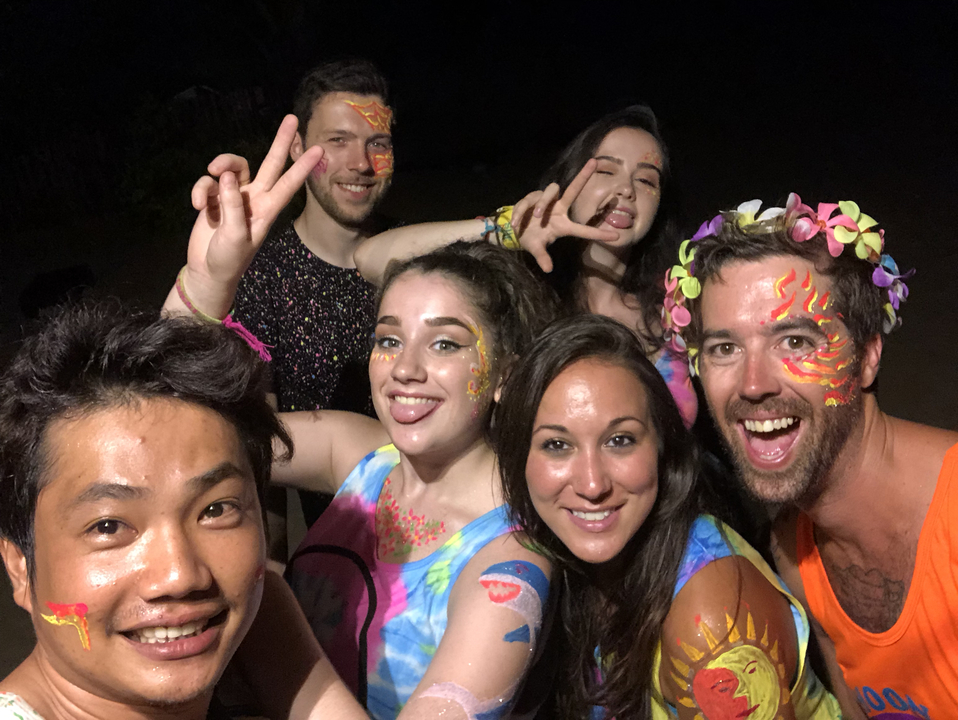 Group of people with painted faces at a night event.