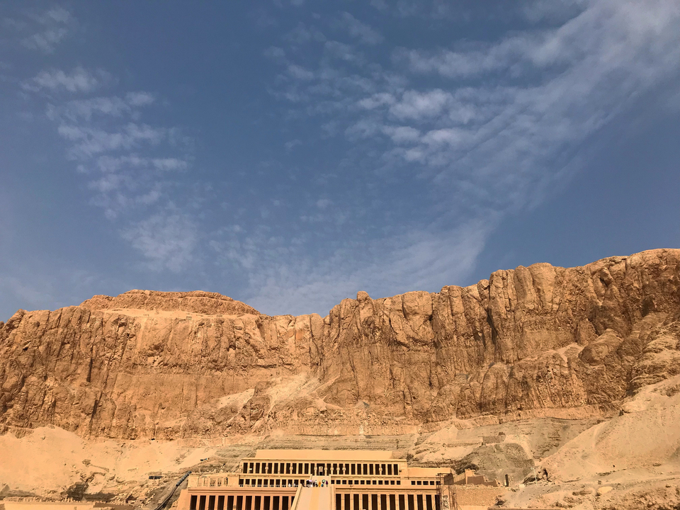 A rugged desert mountain landscape under a vast sky.