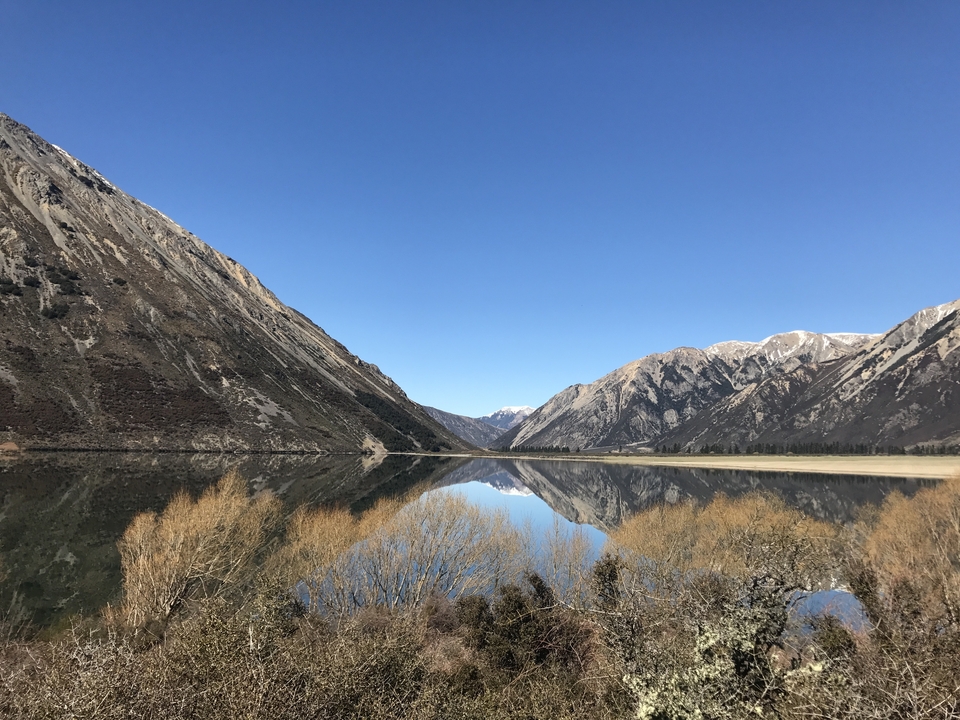 Serene lake with mountain reflection at Arthur's Pass.