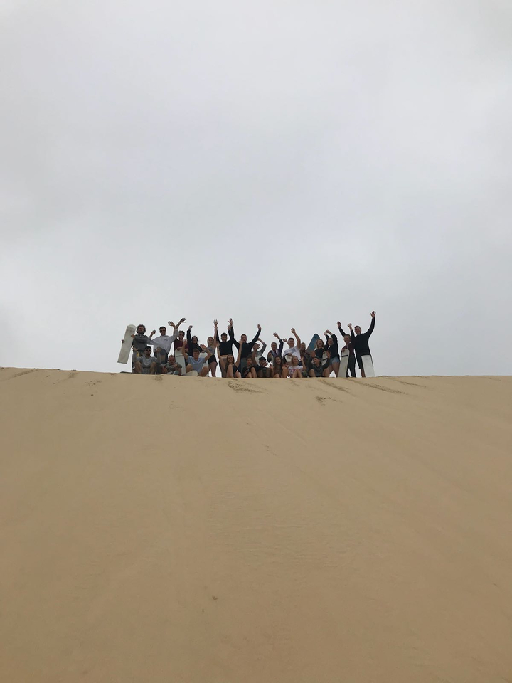 Group of people posing at the top of a sand dune.