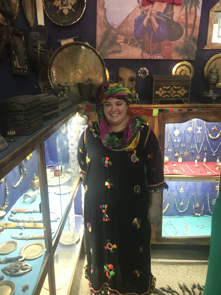 Person in colorful attire with jewelry displays.