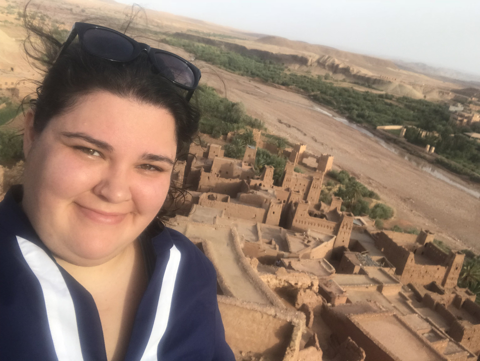 Person with sunglasses in a desert landscape.