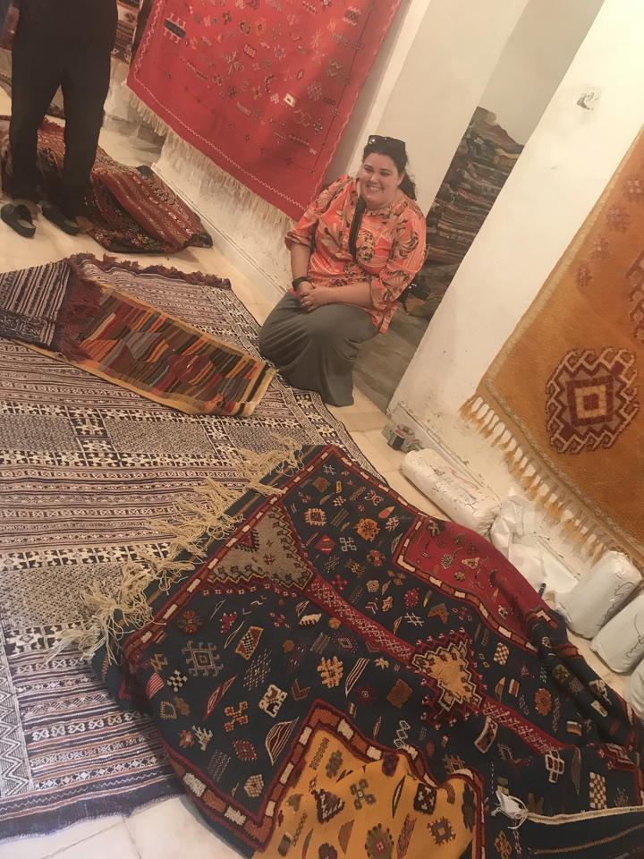 Person displaying colorful traditional textiles.