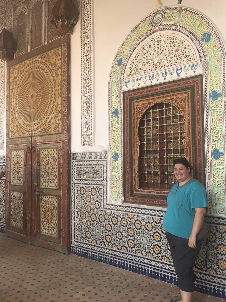 Person in front of intricately decorated building.