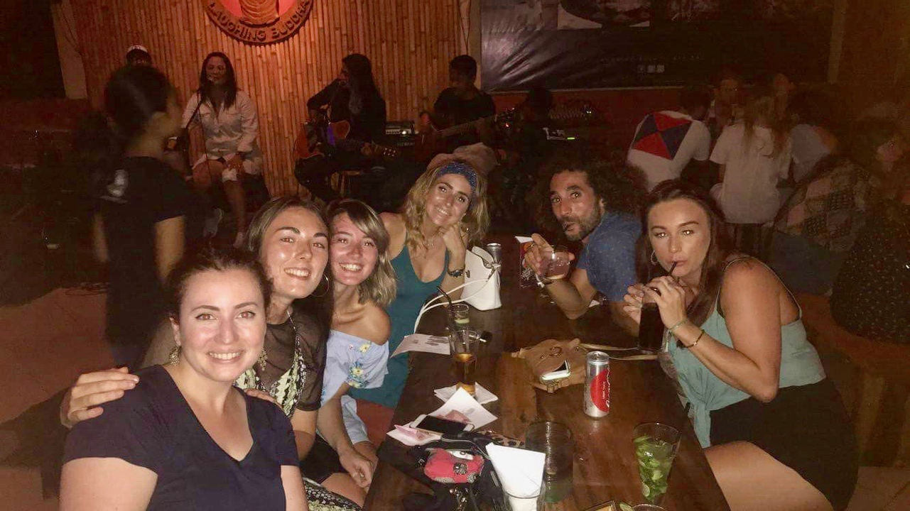 Group of people at a bar or indoor setting.