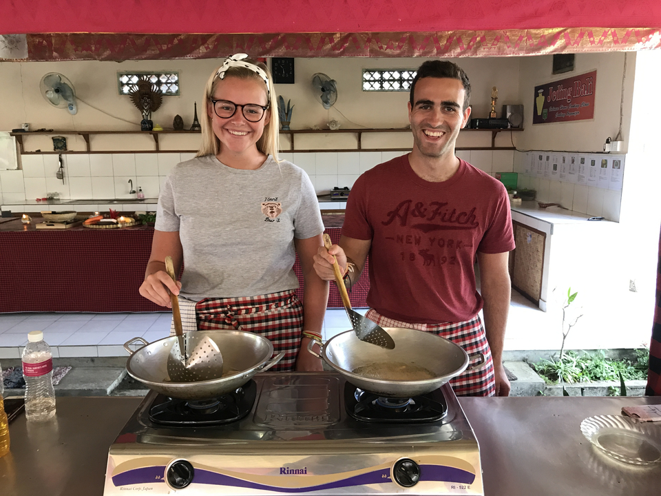 Two people cooking with traditional attire.