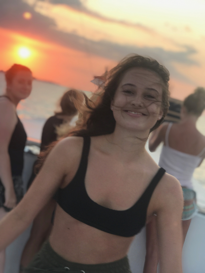 Image floue de personnes sur un bateau au coucher du soleil.