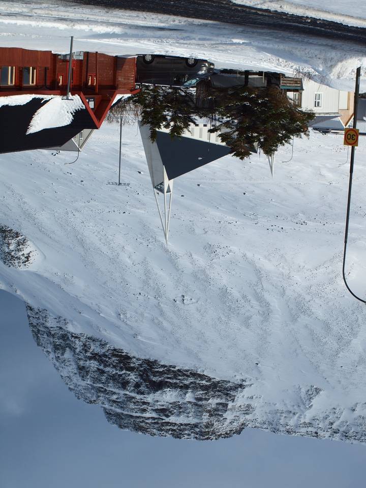 Pueblo nevado bajo una montaña durante el día.