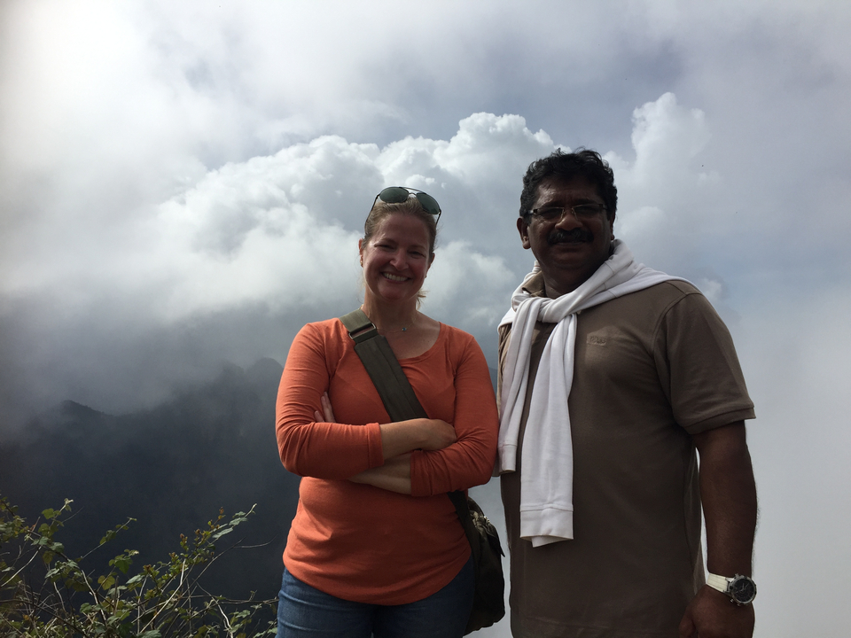 Deux personnes posant devant des nuages et des montagnes