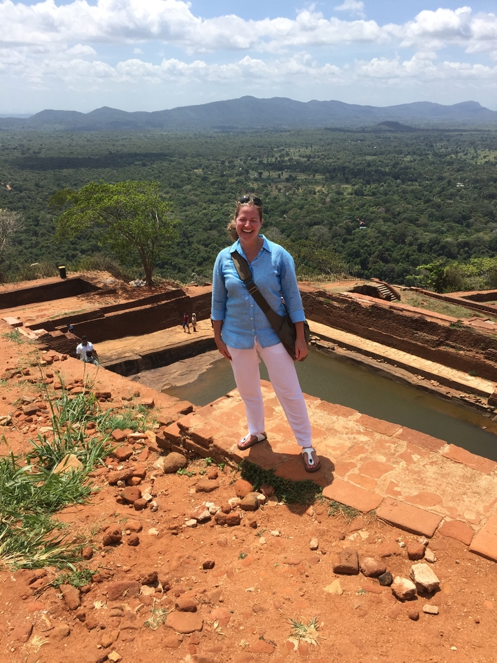 Femme debout près d'une piscine au sommet d'une colline