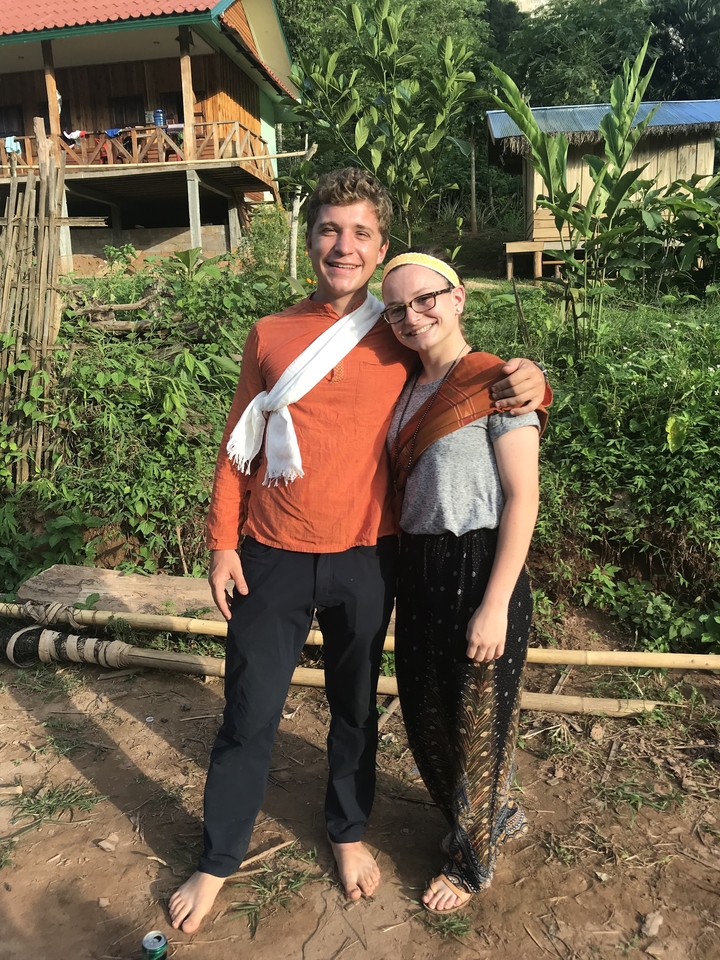 Two people posing outdoors in ethnic clothing.