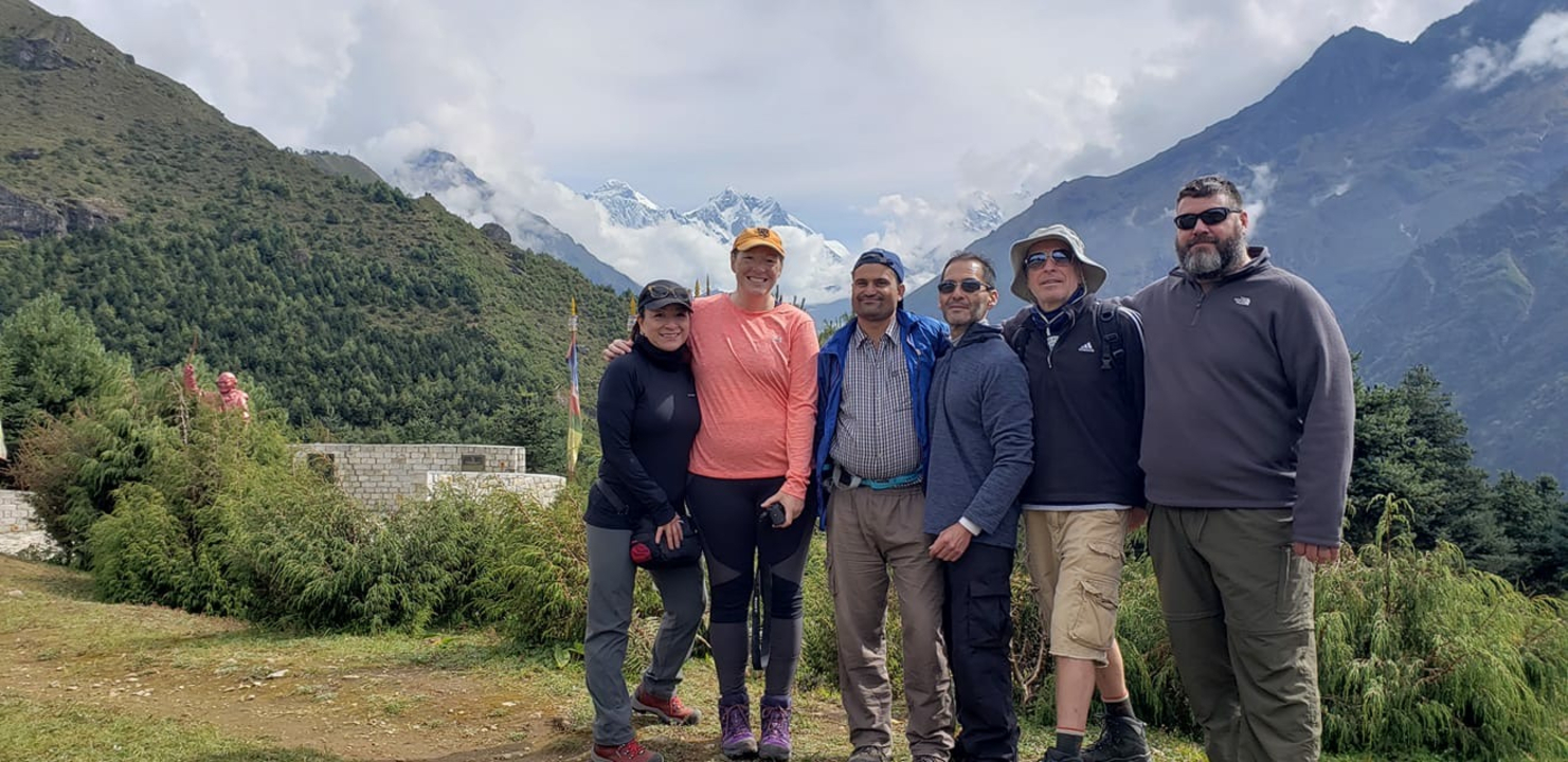 Group of hikers posing with a mountain backdrop.