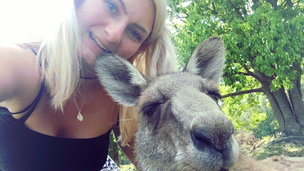 Woman taking a selfie with a kangaroo.