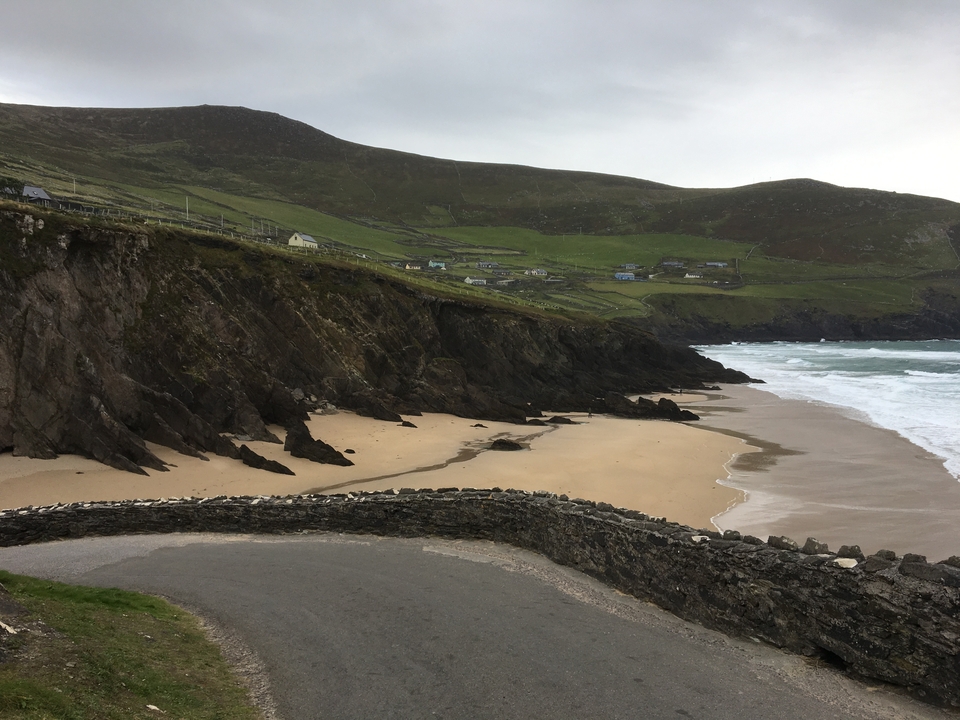 Secluded beach with cliffs and small houses in the background