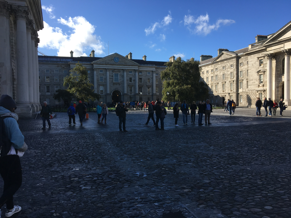 Cour d'un bâtiment historique remplie de touristes