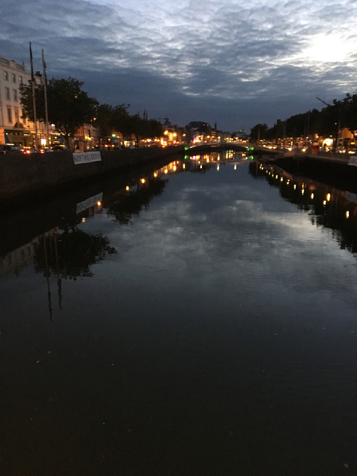Reflection of city lights and a bridge in the water