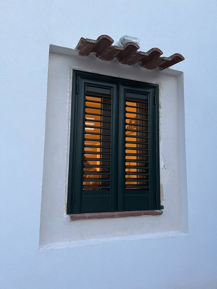 A small window with iron bars viewed from outside.