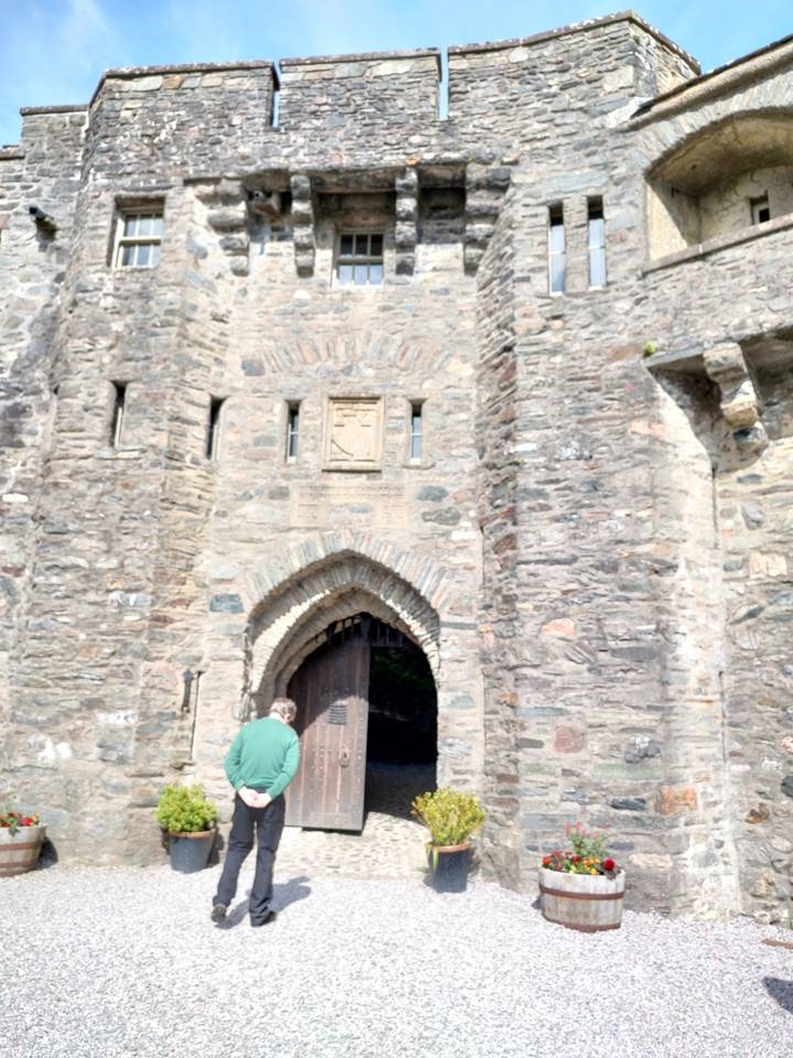 Person standing at the entrance of a stone building.