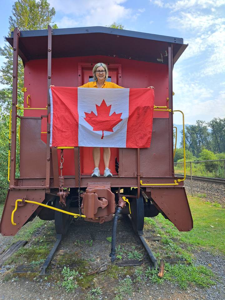 Person with Canadian flag in a train caboose display.