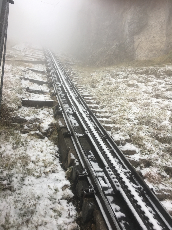 Snow-covered railway tracks on a slope.