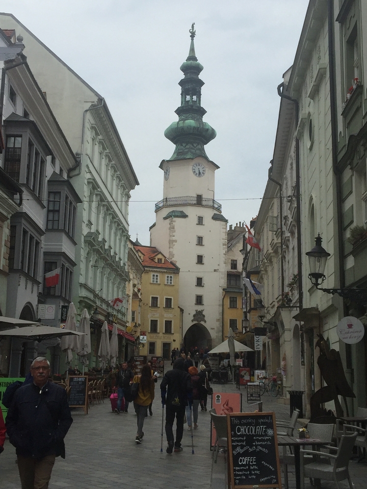 Historic street scene with a prominent clock tower in the background.