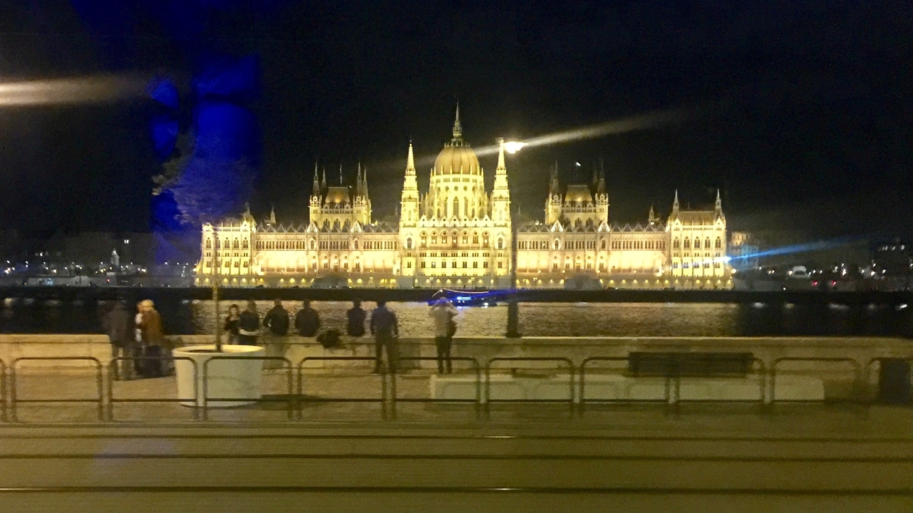 Stunning night view of a lit Parliament Building across a river.