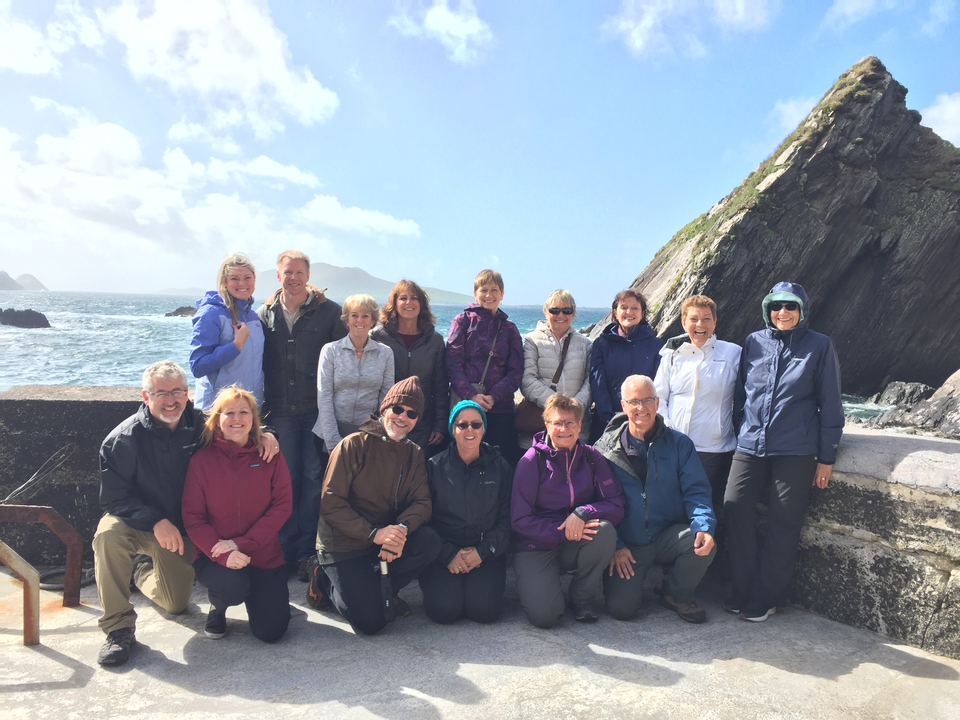 Photo de groupe sur une côte rocheuse avec des vagues qui se brisent contre les falaises.