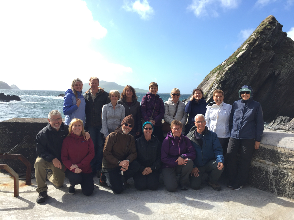 Photo de groupe sur une côte rocheuse avec des vagues qui se brisent contre les falaises.